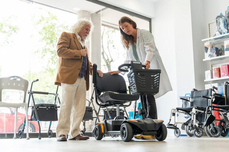 Older man testing out a mobility scooter in a mobility shop.